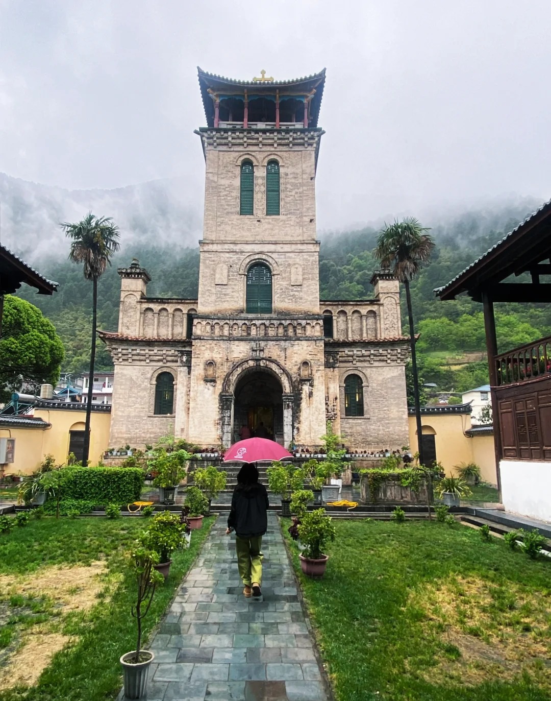 Facade of the 1909 French Catholic church at Cizhong on the Mekong — stone bell tower, Chinese tiled eaves, working Tibetan-Catholic parish