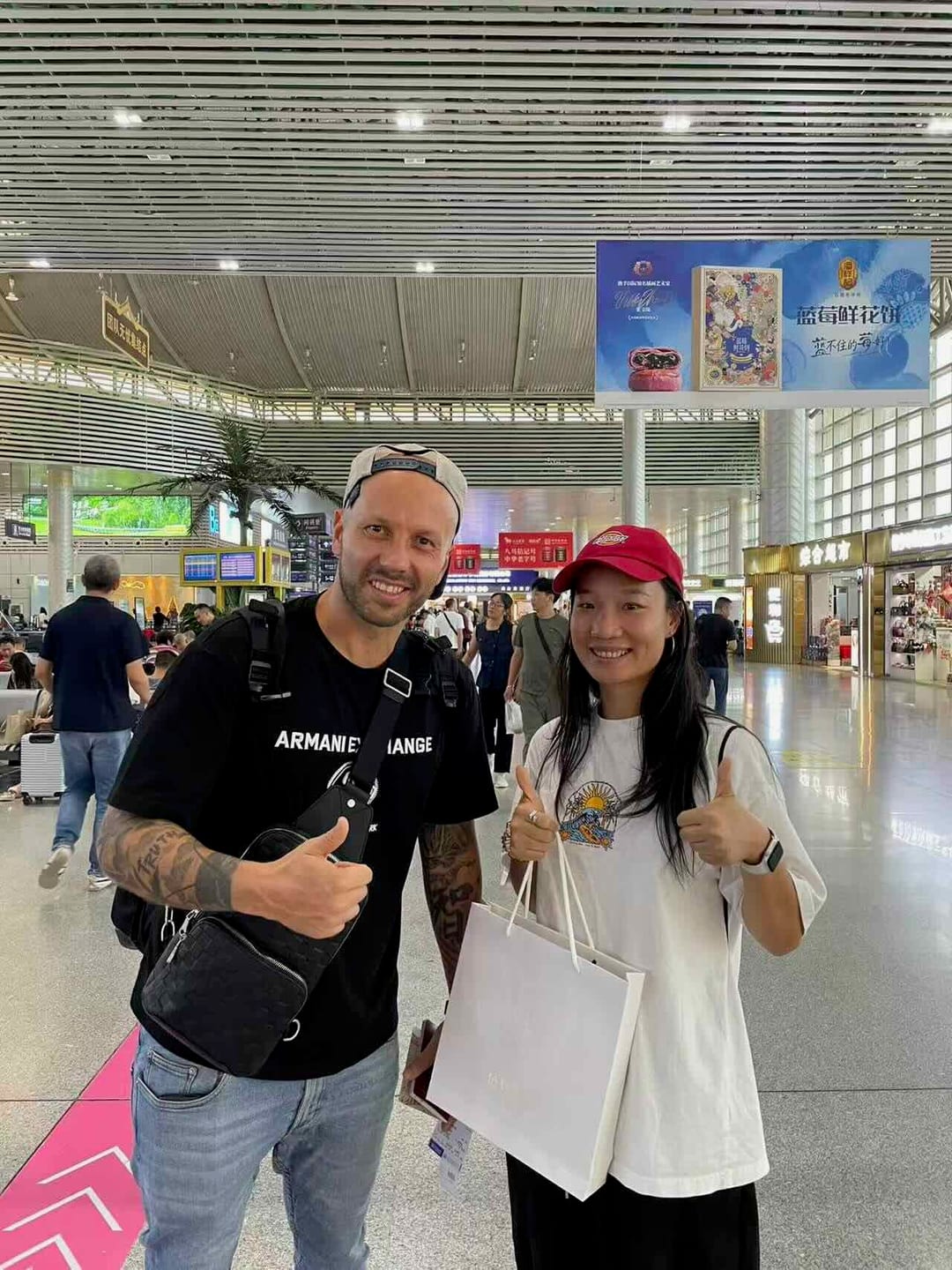Mario and his Boutique China guide at Jinghong airport check-in, thumbs up, farewell gift in hand