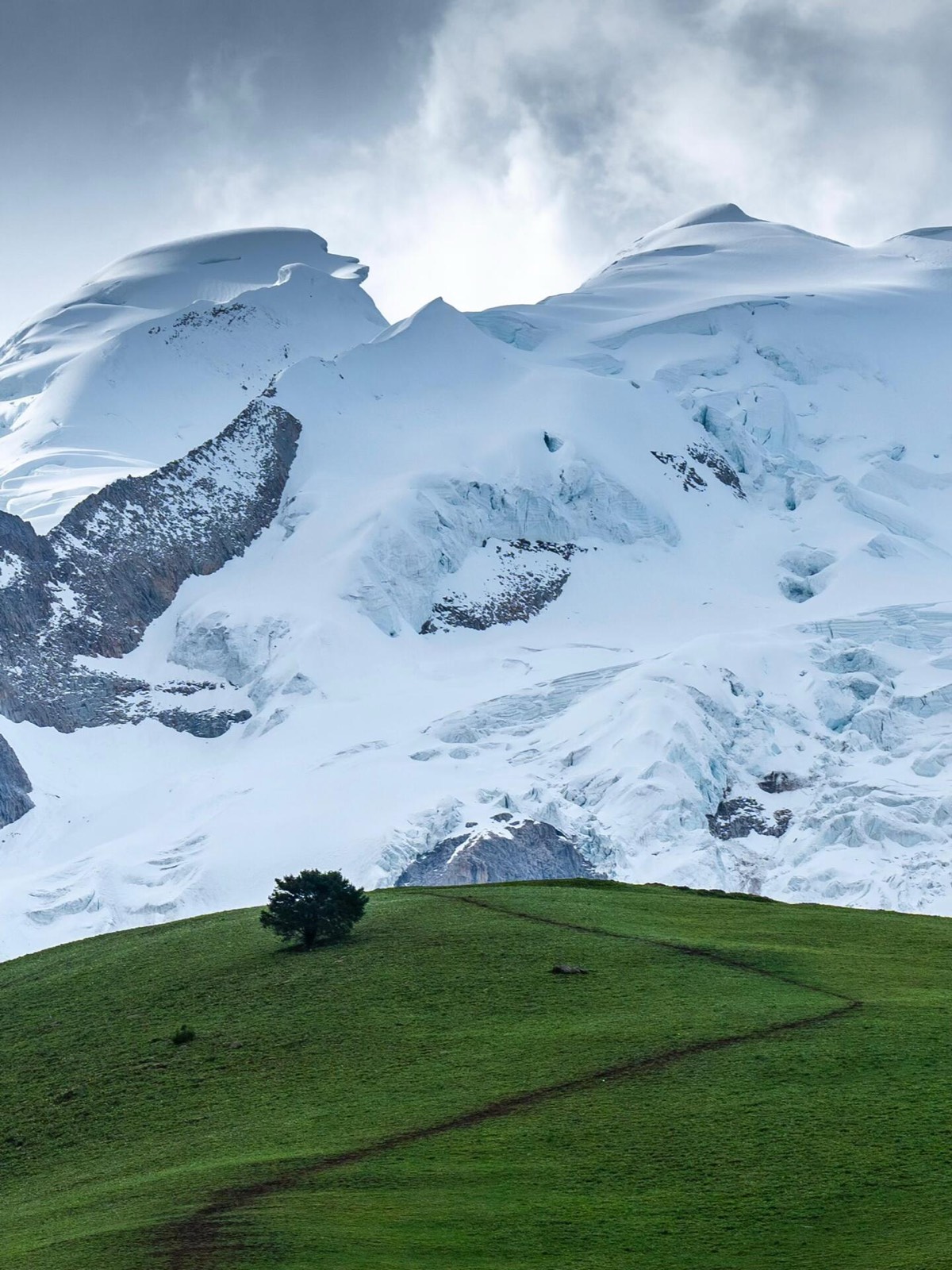 A dramatic, high-contrast shot of the thick, white glacial ice and snow formations atop the Gani-Nie