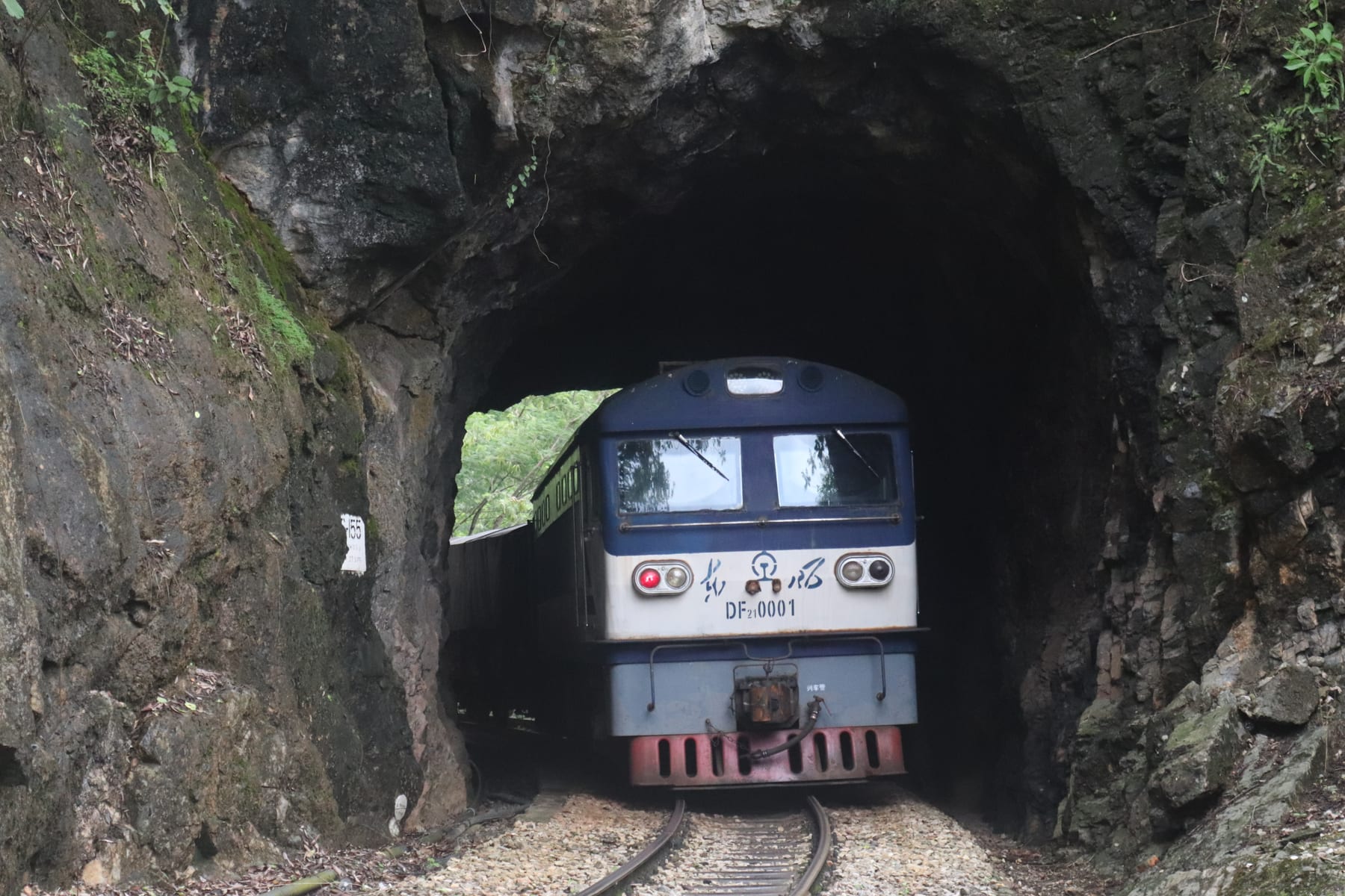 A metre-gauge freight train coming out of a rock tunnel on the Yunnan–Vietnam Railway in Pingbian, Honghe