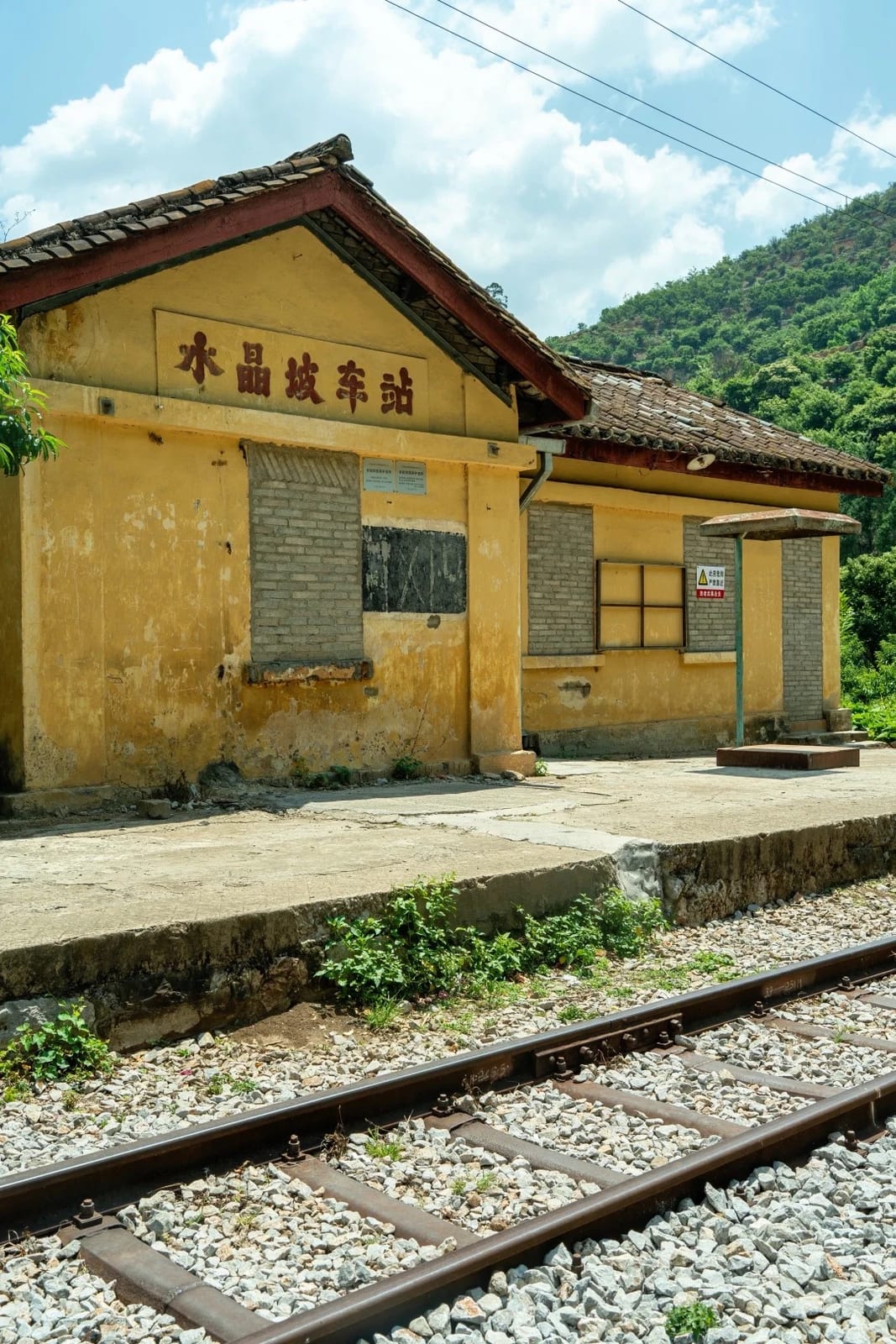 Shuijingpo station on the Yunnan–Vietnam Railway — a yellow station house with its name on the wall