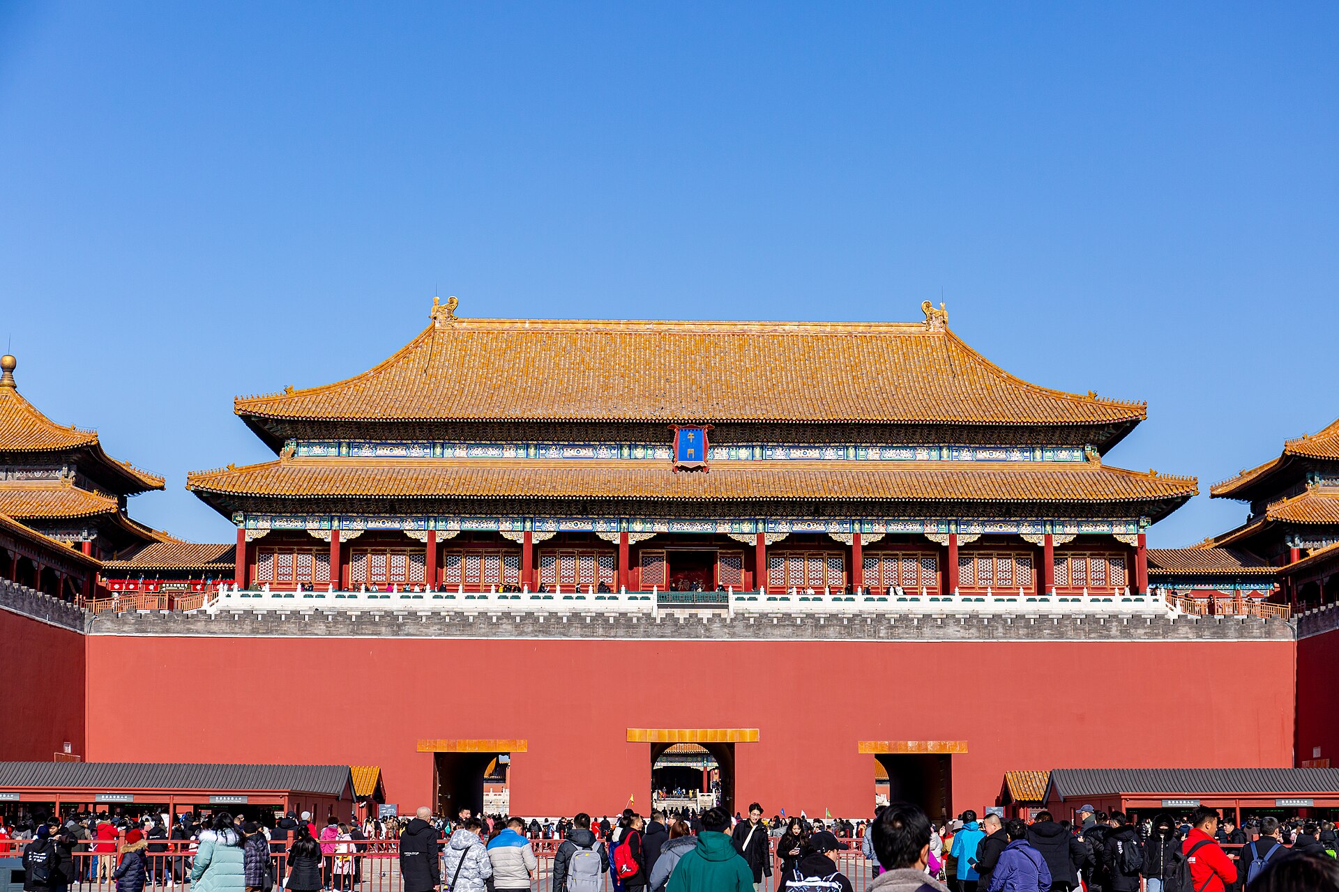 The vermilion-and-gold Meridian Gate (午门), the grand southern entrance to the Forbidden City (故宫), under a clear blue sky, Beijing