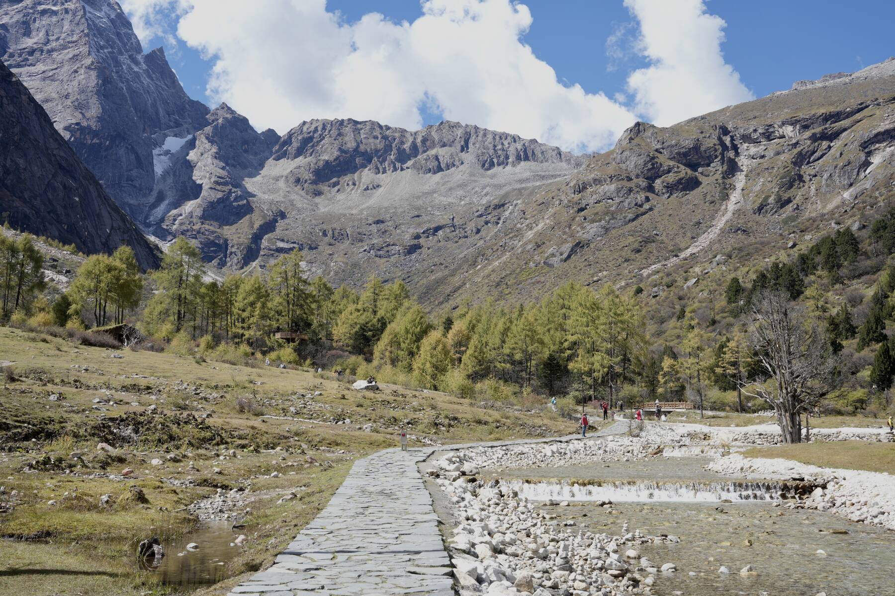 Stone path through Bipeng Valley alpine meadow — Day 3 descent