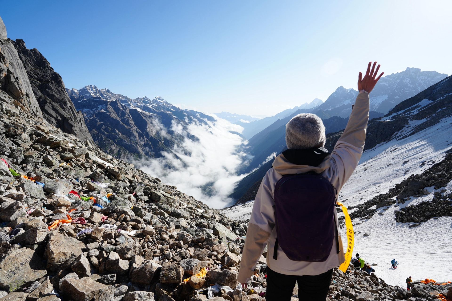 Prayer flags at the Muluozi Pass with clouds and peaks — Day 3 high point