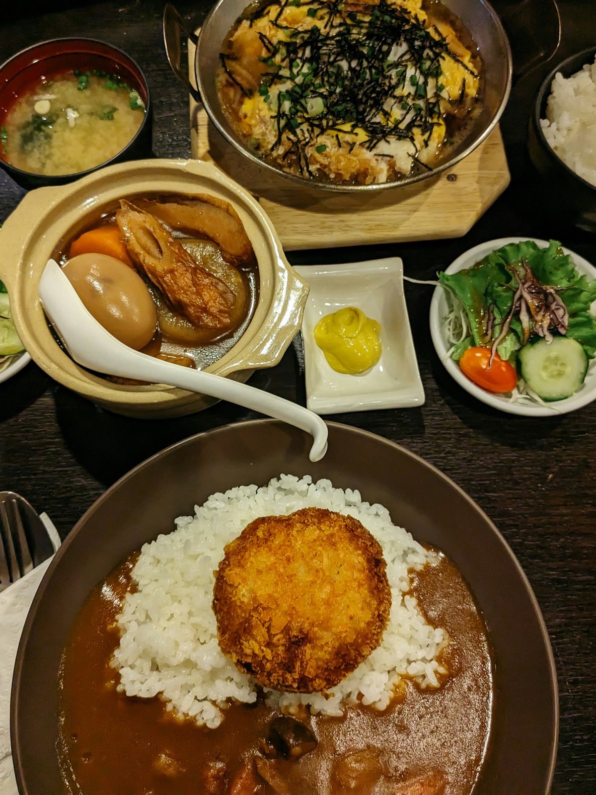 Japanese-style set meal with curry rice topped by a fried croquette, clay-pot stew, miso soup and side salad in Chengdu.