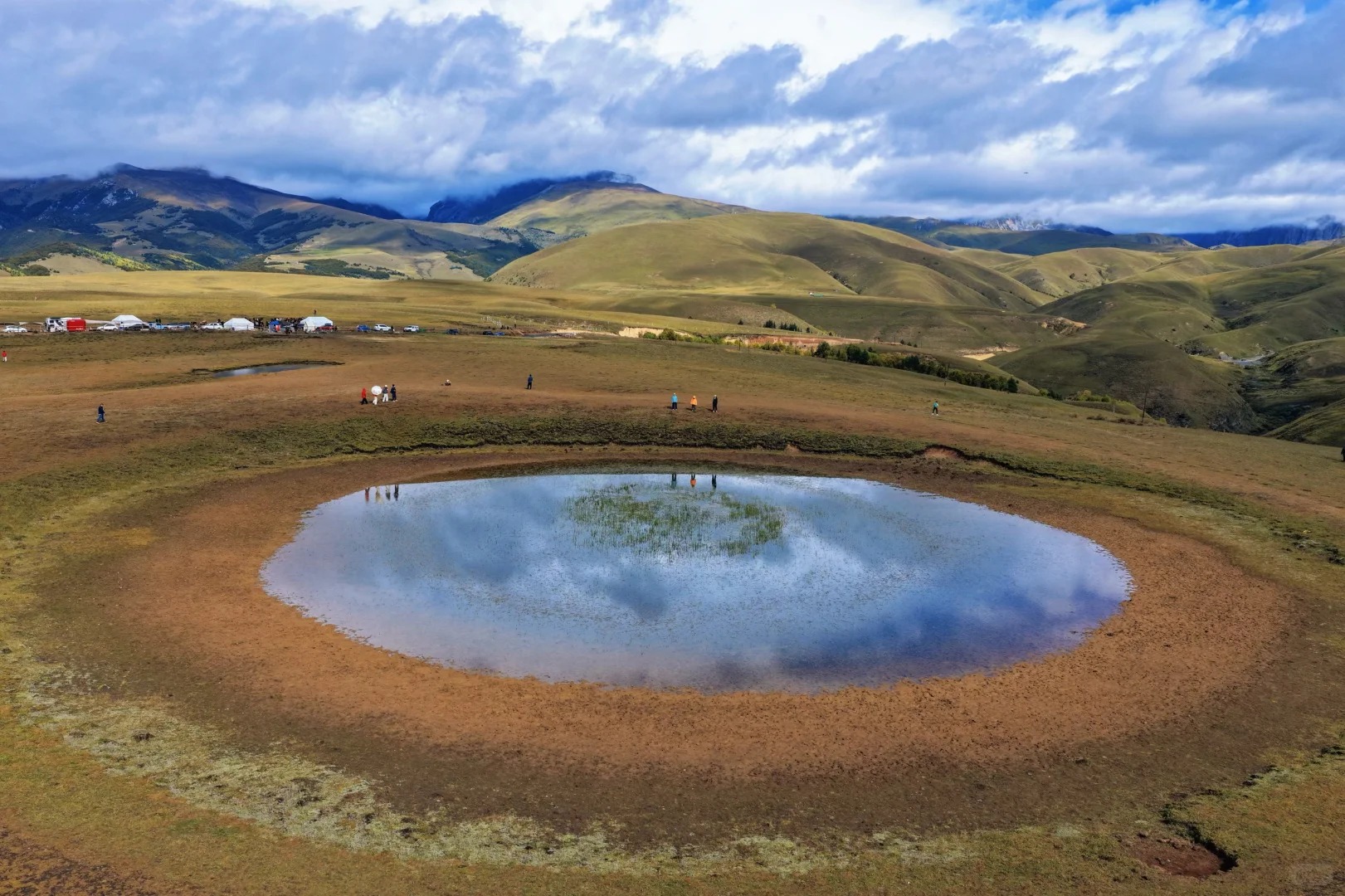 Aerial view of Eye-of-Genie pond with meadow camp below Genie Sacred Mountain