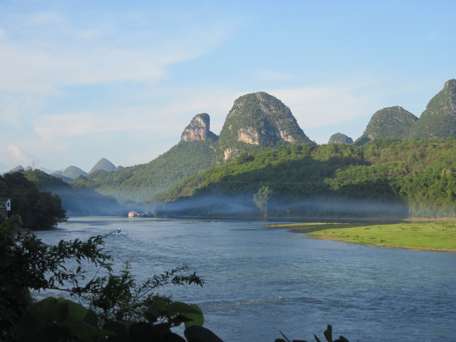 Dawn mist drifting over the Li River (漓江) below golden-lit karst peaks, Guilin