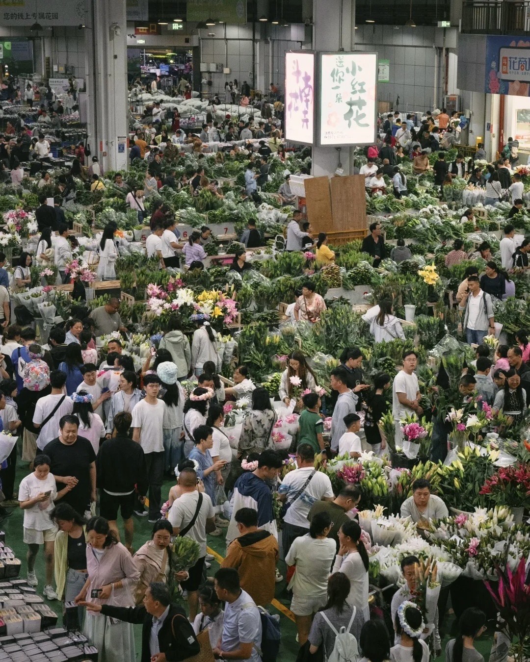 Crowded indoor flower market in Kunming packed with vendors and bundles of fresh cut lilies and blooms