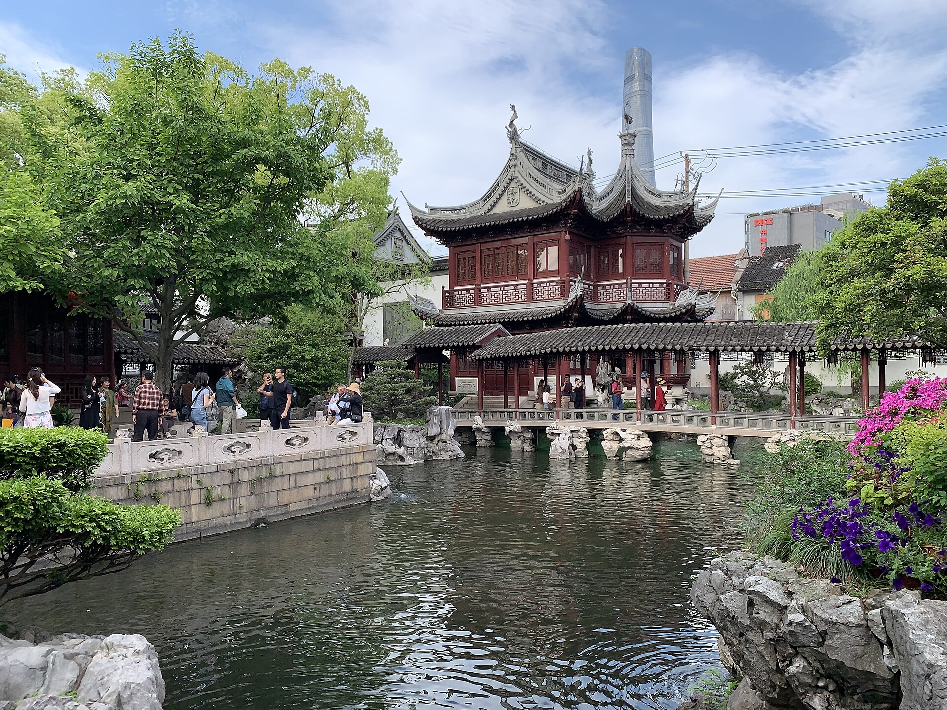 Pavilions and a lotus pond at Yu Garden (豫园), a boatman poling past the rockery in the old town of Shanghai