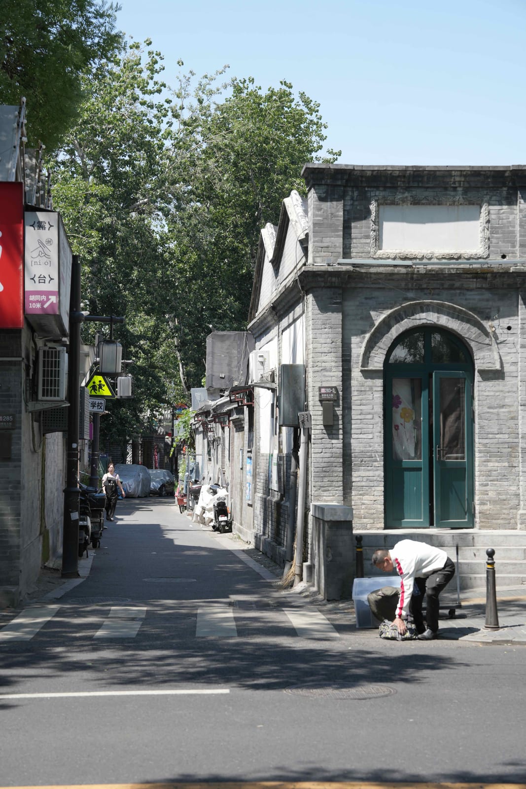 A grey-brick hutong lane with a carved doorway, Beijing — Classic China pandas & Zhangjiajie tour