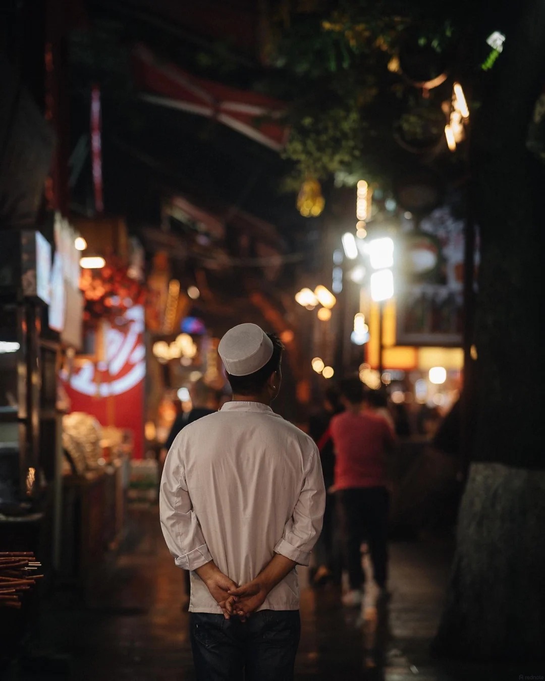 A Hui vendor in a lantern-lit lane of Xi'an's Muslim Quarter — Classic China tour