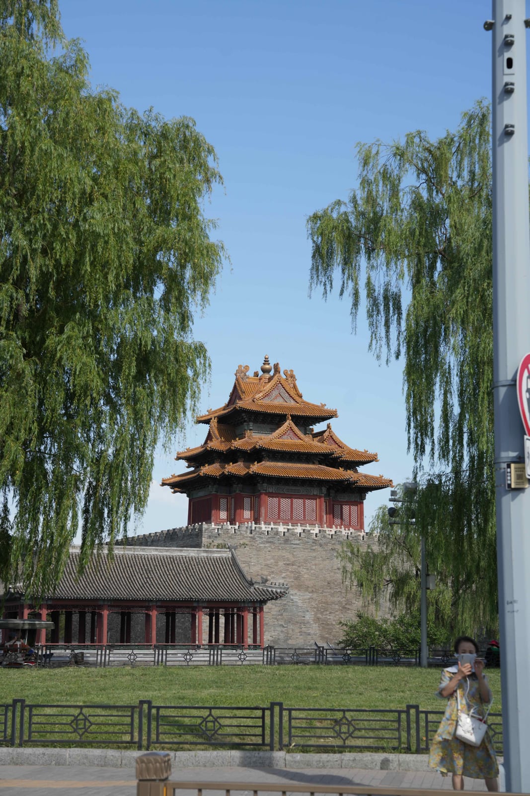 The Forbidden City's corner tower (角楼) above the moat, framed by willow branches, Beijing — Classic China & Yunnan tour