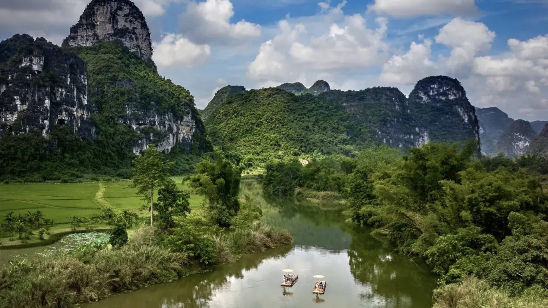 Bamboo rafters navigating the Li River under blue sky with towering karst peaks, Guilin — Guilin private tour