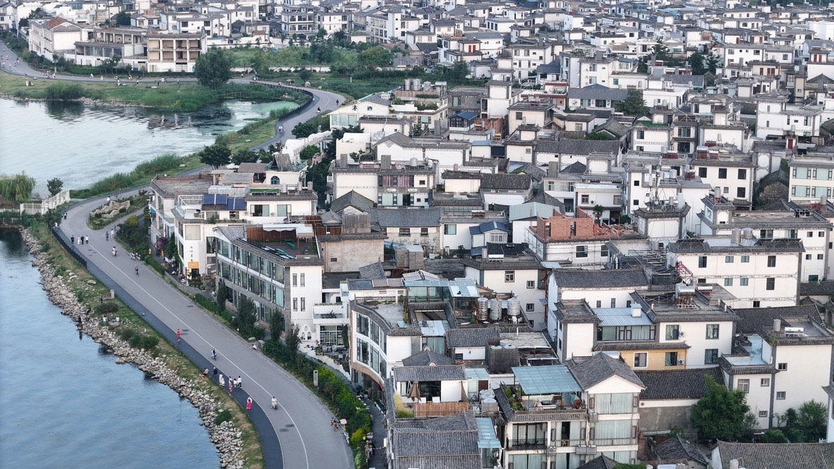 Curving paved lakeside path along Erhai's east shore through Bai villages — the family cycle route