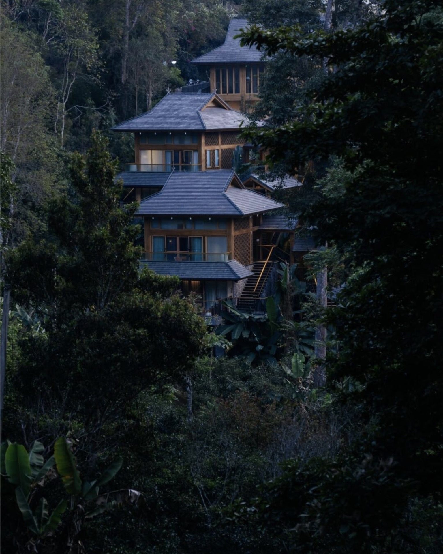 Bolian Jingmai tea manor at evening — the Relais & Châteaux estate inside a working Pu'er tea forest