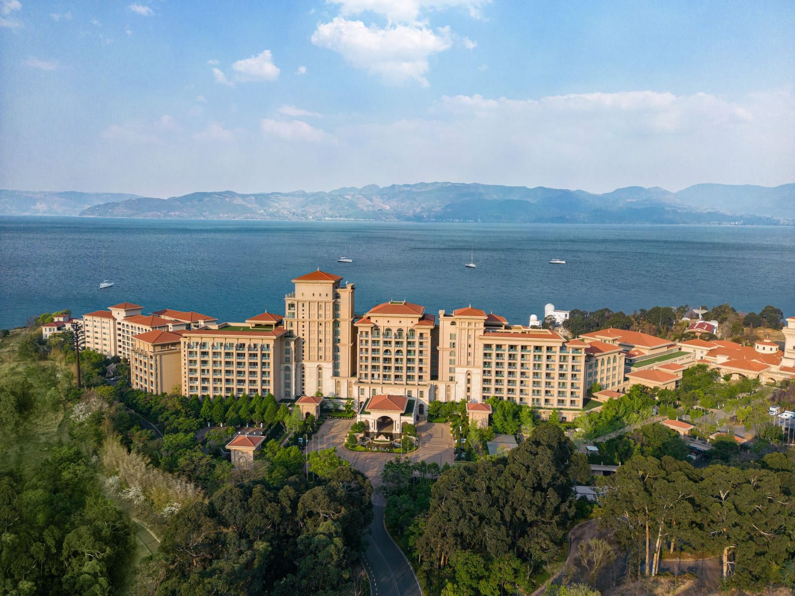 Hilton Yuxi Fuxian Lake (抚仙湖希尔顿酒店) — the resort on its hillside above the east shore, Fuxian Lake and the far mountains behind