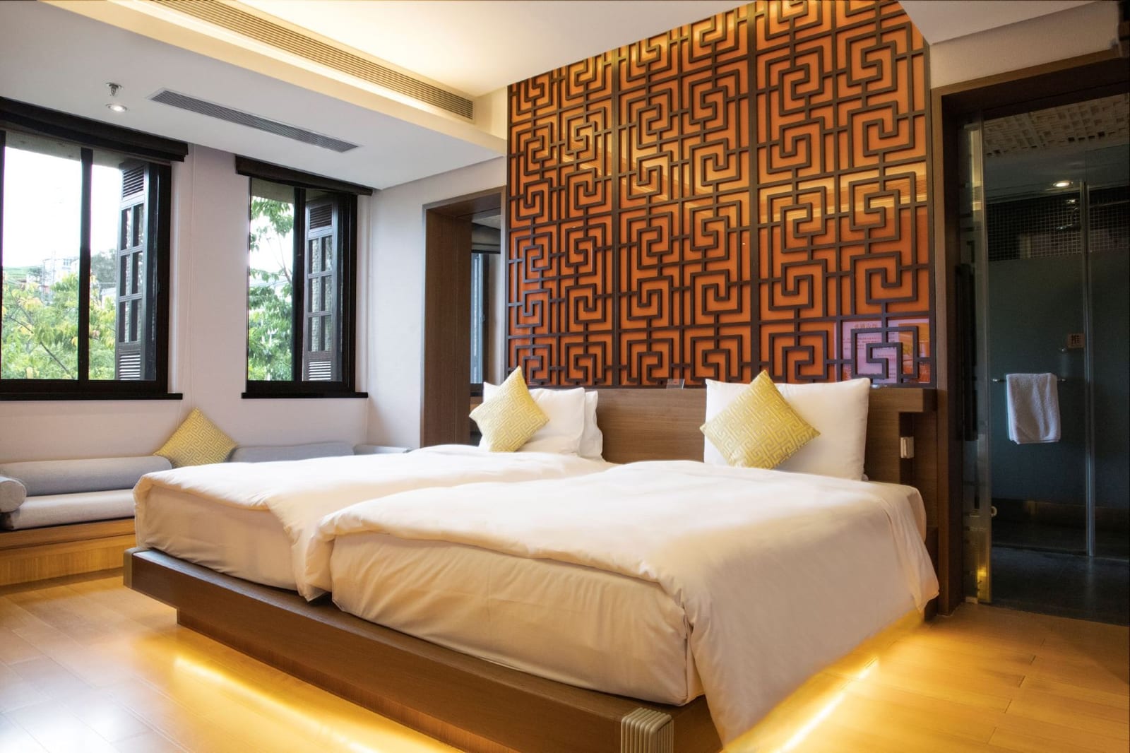 Wanda Vista Yuxi Fuxian Lake — a twin room with a carved fretwork screen behind the beds and timber floors