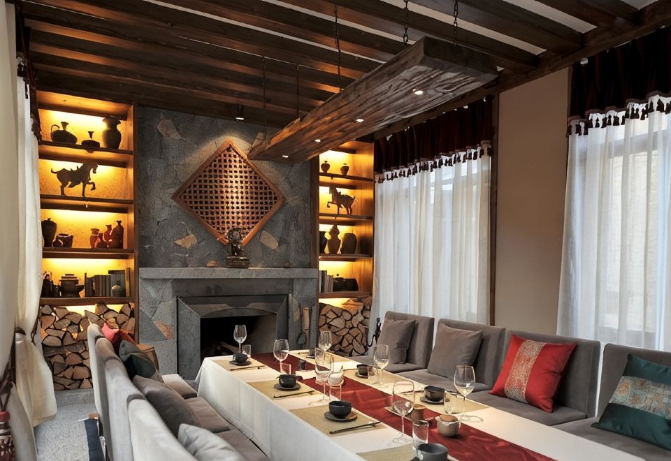 Arro Khampa — dining hall with stone fireplace and Tibetan textiles