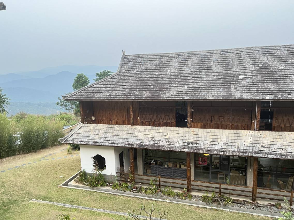 Bulang Yuni Inn — the two-storey Bulang timber house above the ridges of the Jingmai tea forest