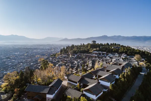 Aerial view of tiled courtyard rooftops spread across a hillside above an old town at Dayanaman.