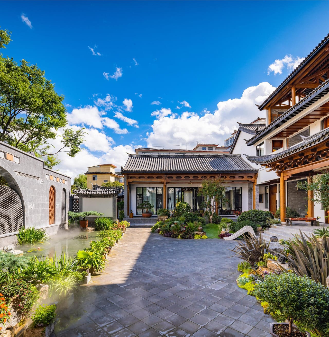 He Ting · Awamei — the paved courtyard and pavilion under a clear Lijiang sky