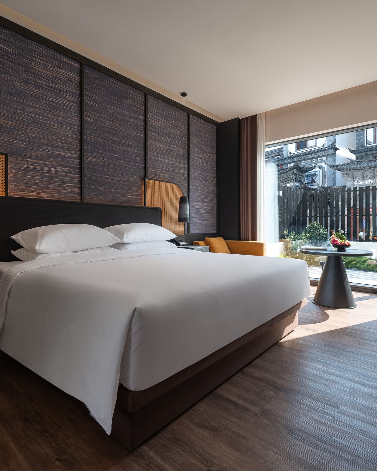 Kasion Erhai — a garden king room, glass doors opening to a planted terrace