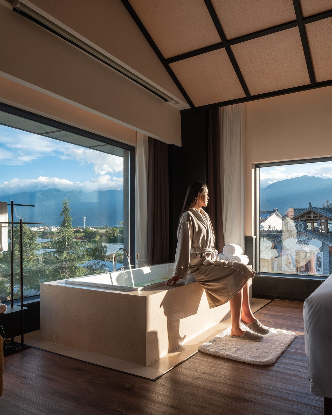 Kasion Erhai — a Guanlan suite with a freestanding tub at the window, looking out to the Cang Mountains