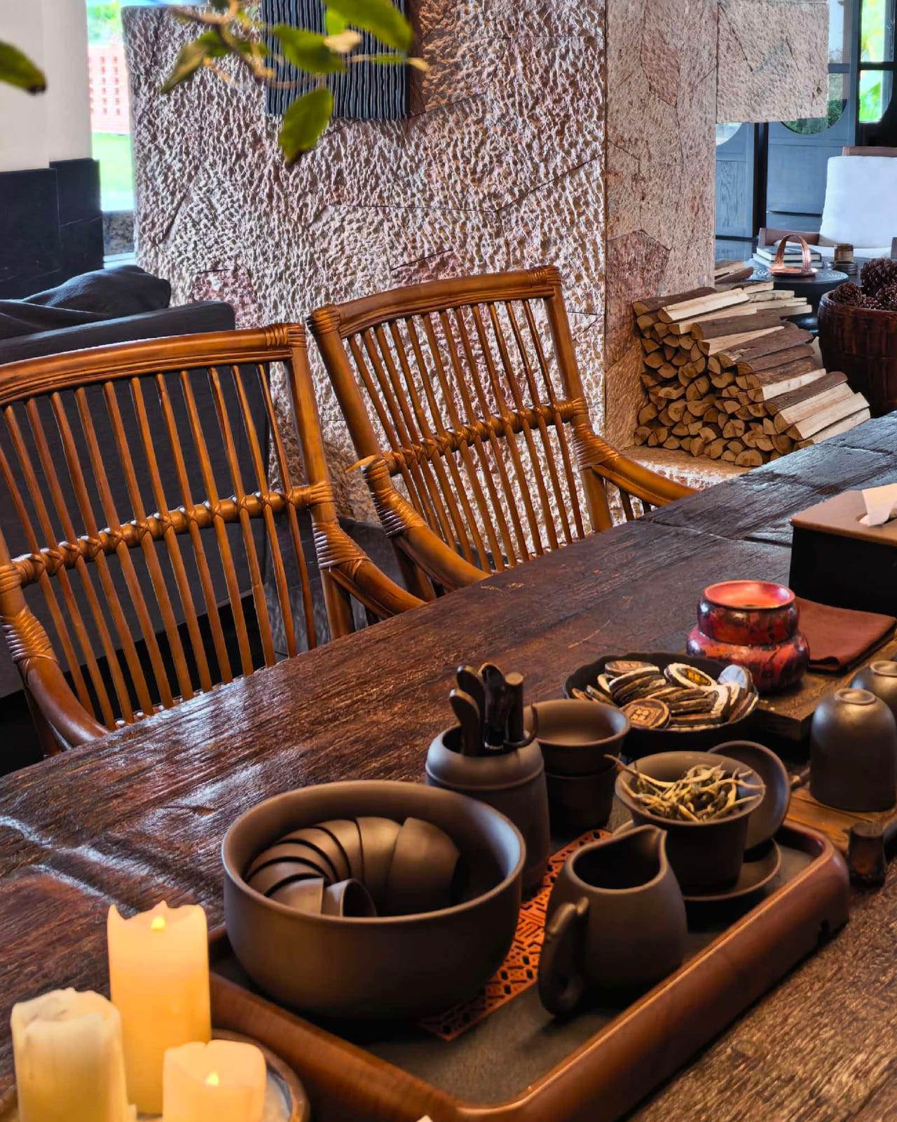 Kasion Erhai — the tea room, rattan chairs drawn up to a long timber tea table