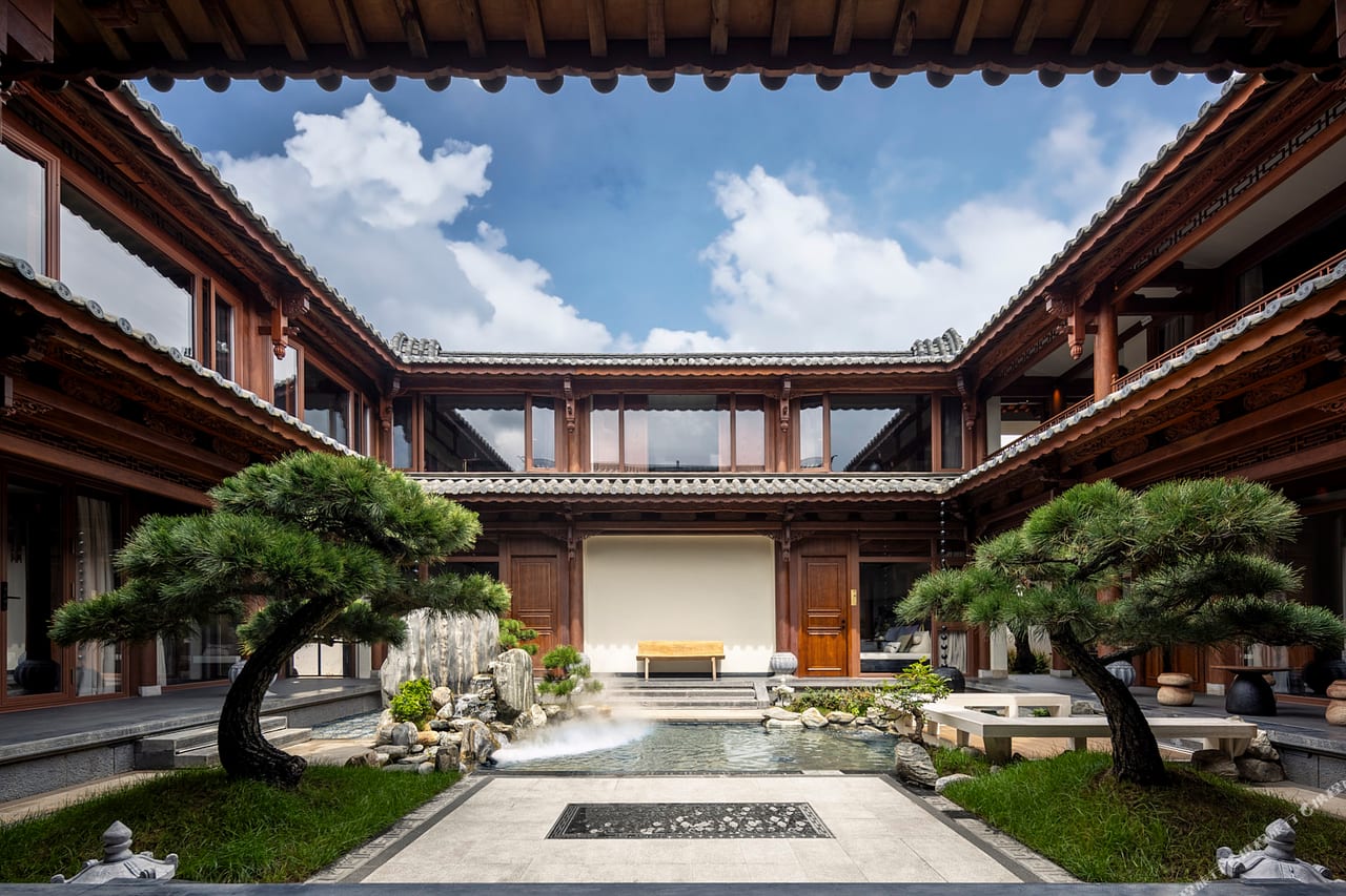 Kogongdi — the central courtyard with black pines and a reflecting pool, timber galleries on all four sides, Shaxi
