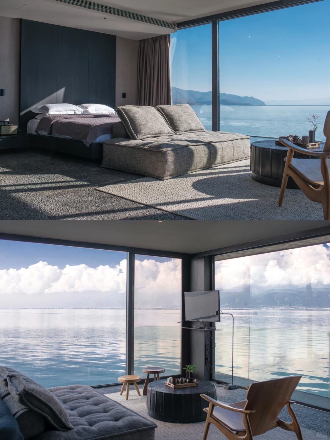 Bedroom with grey chaise, wooden armchair and floor-to-ceiling corner windows framing a calm lake and distant mountains.