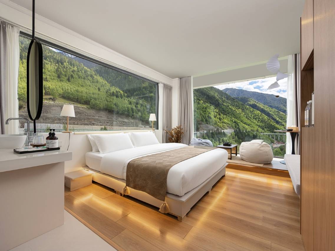 Muyun Valley — platform-bed room with panoramic windows onto the forested slopes above Rilong