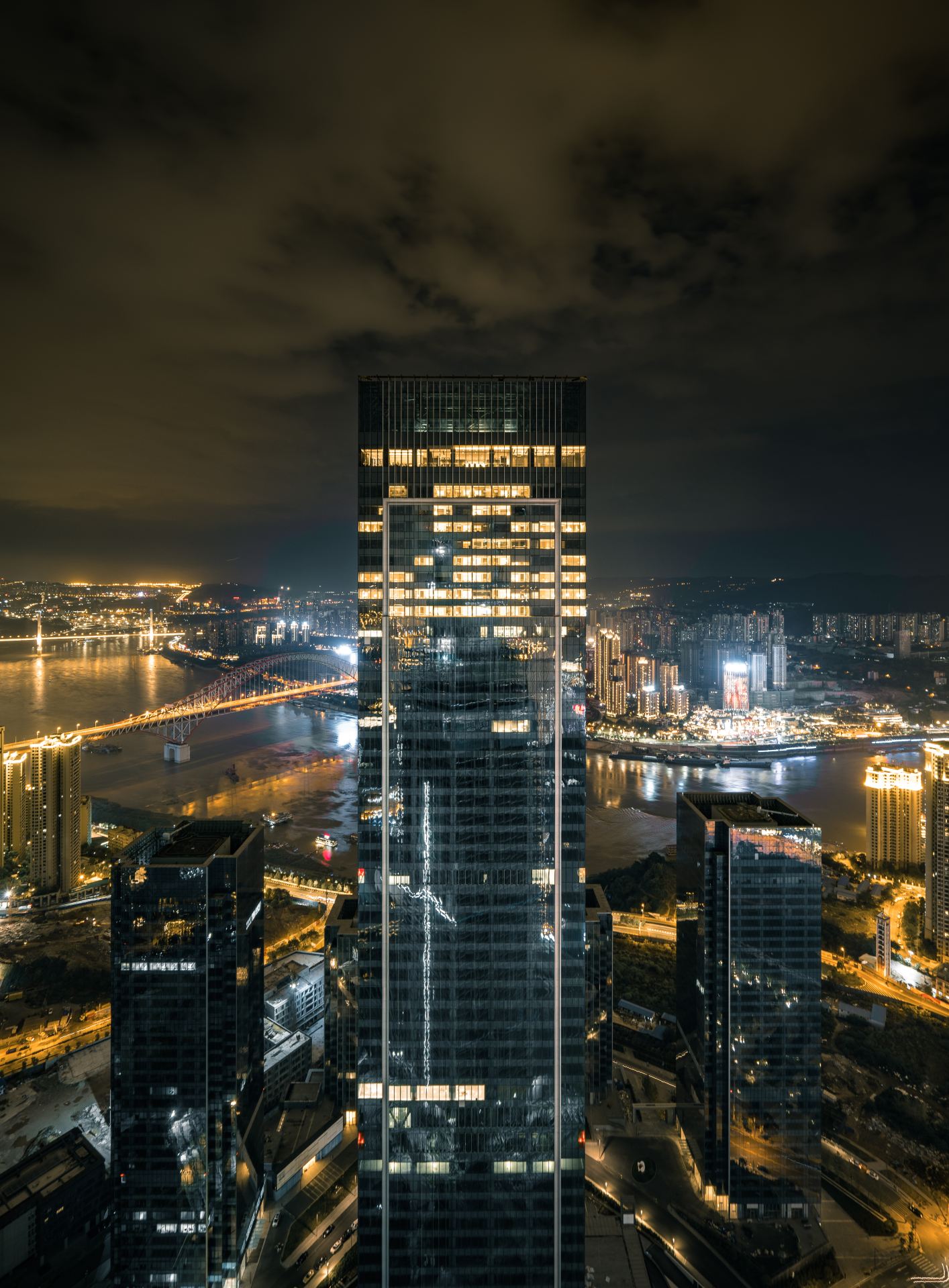Niccolo Chongqing (重庆尼依格罗酒店) — the crown of the Chongqing IFS tower at night above the Yangtze–Jialing confluence