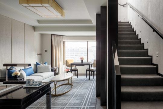 The Peninsula Beijing (北京王府半岛酒店) — the living room of a Duplex Suite, a staircase rising to the bedroom above