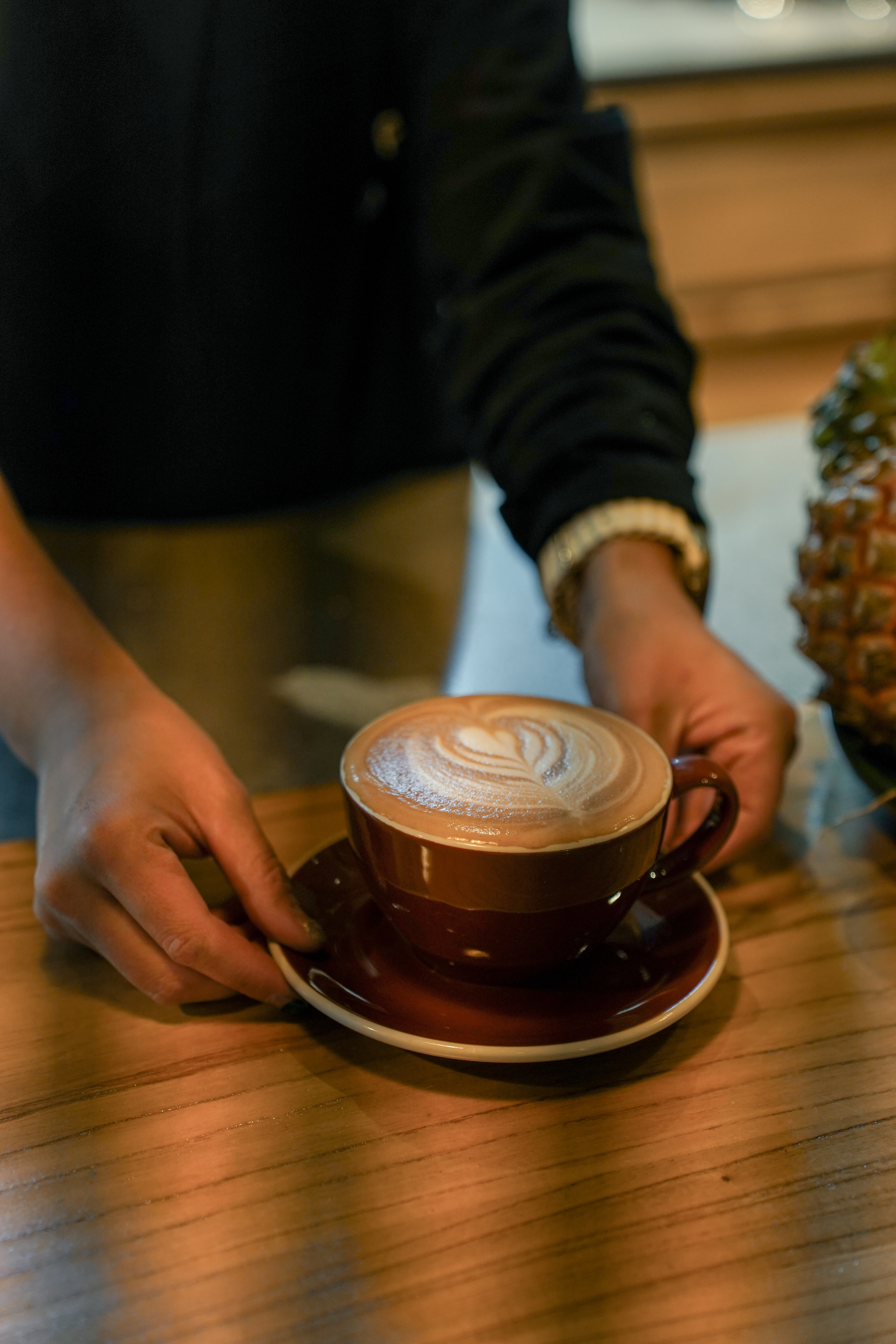 Porcelain Inn — barista serving a rosetta-art latte in the café