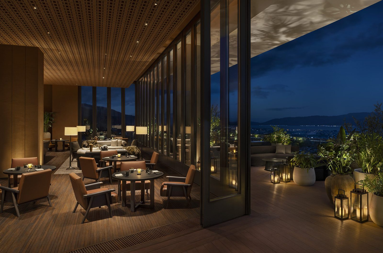 KUSHO's timber-ceilinged dining room opening onto a lantern-lit terrace at dusk, the lights of Dali and Erhai below.