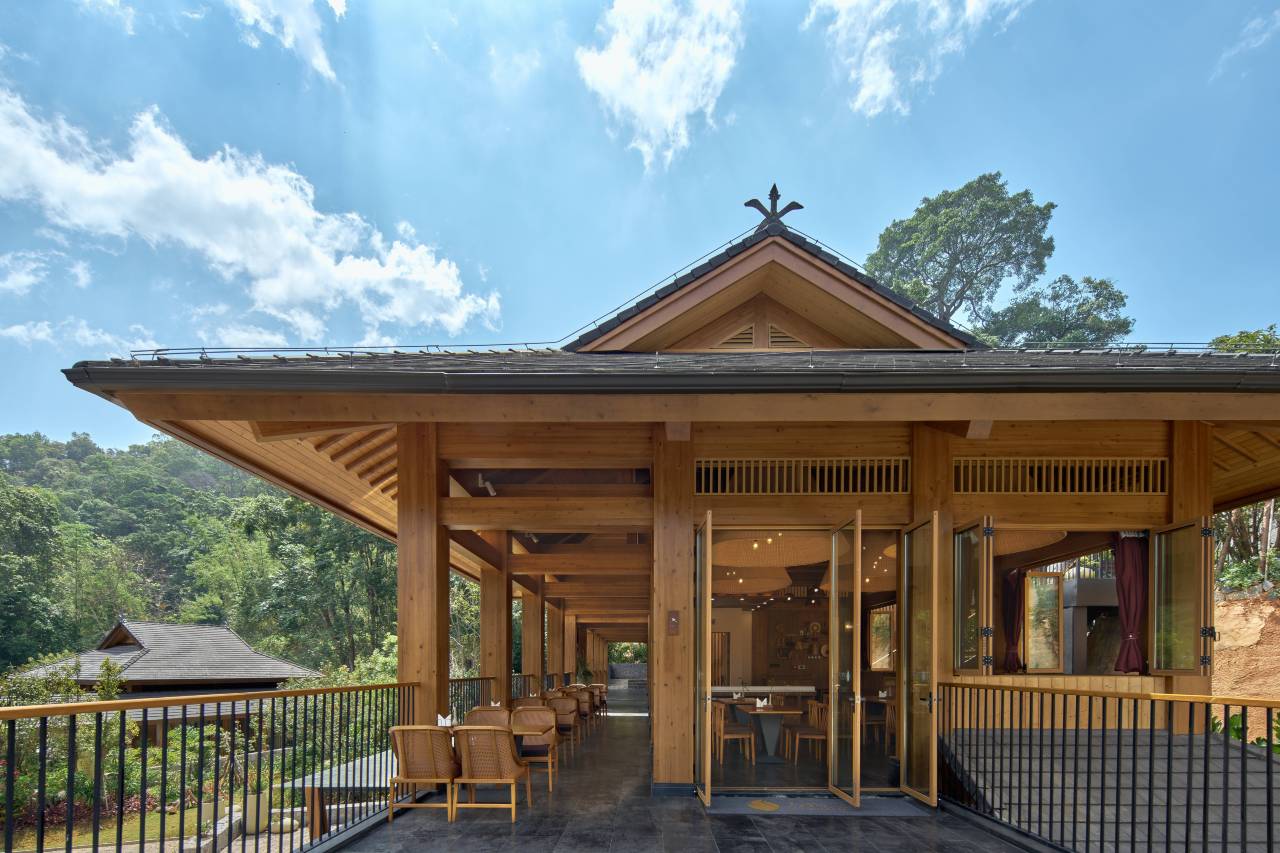 Vipaxana — open-sided timber dining pavilion with terrace seating over the tea forest, Jingmai Mountain