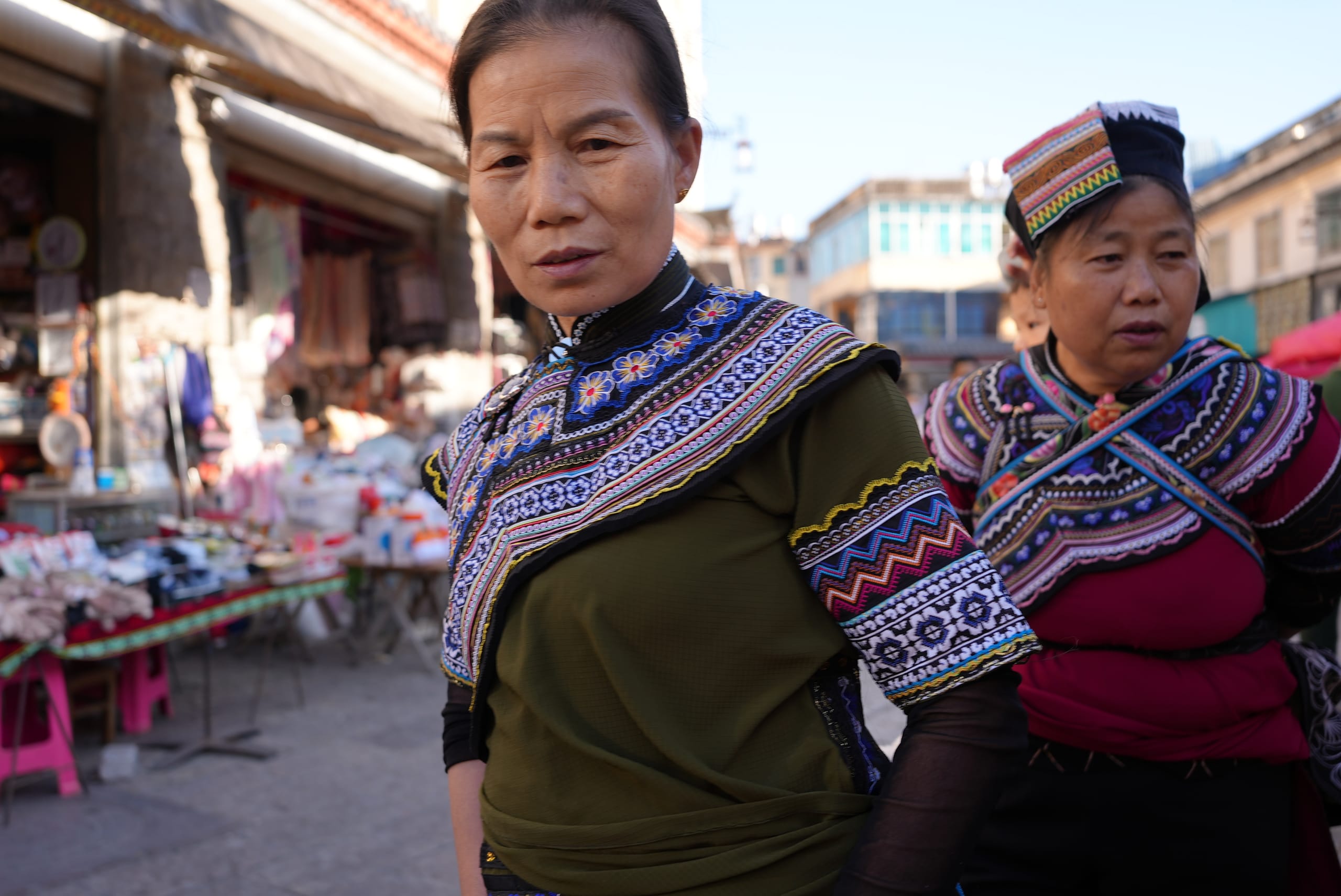 Hani women in traditional embroidered dress at a local market