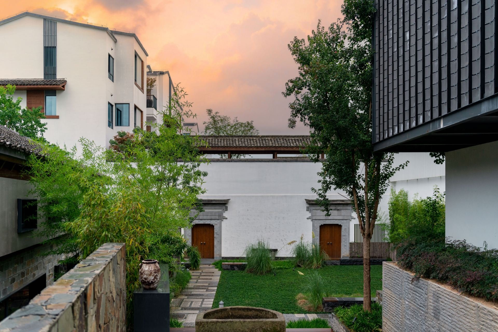 Tanhouse Hot Spring Resort — whitewashed Huizhou-style buildings around a garden at dusk