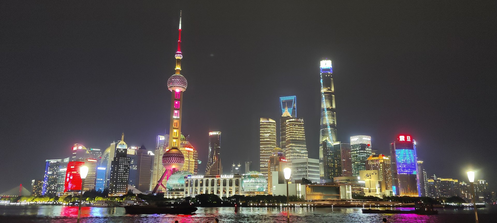 The Pudong skyline lit up at night across the Huangpu