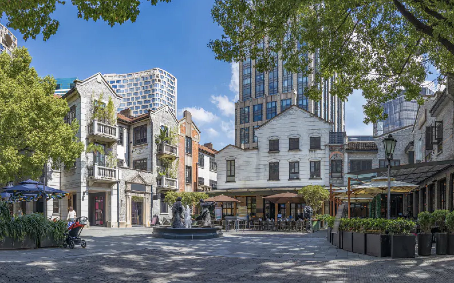 Restored lane houses and cafés around a fountain square in Shanghai