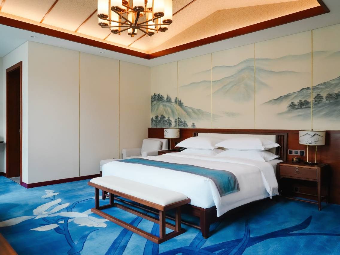 Guanfang Garden Hotel — a king room under an ink-landscape mural