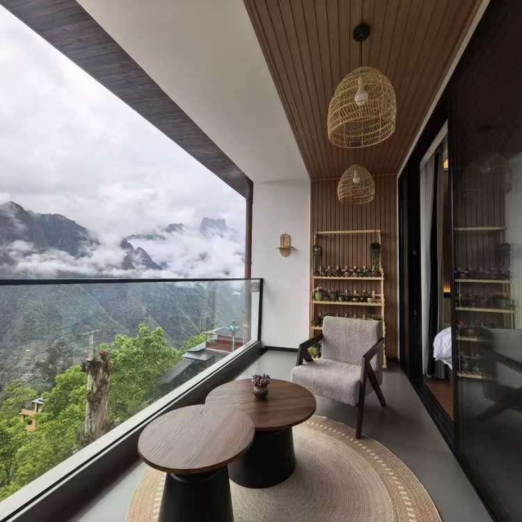 Shanjing Yungu — a lounge glazed the full width of the valley, cloud filling the gorge below