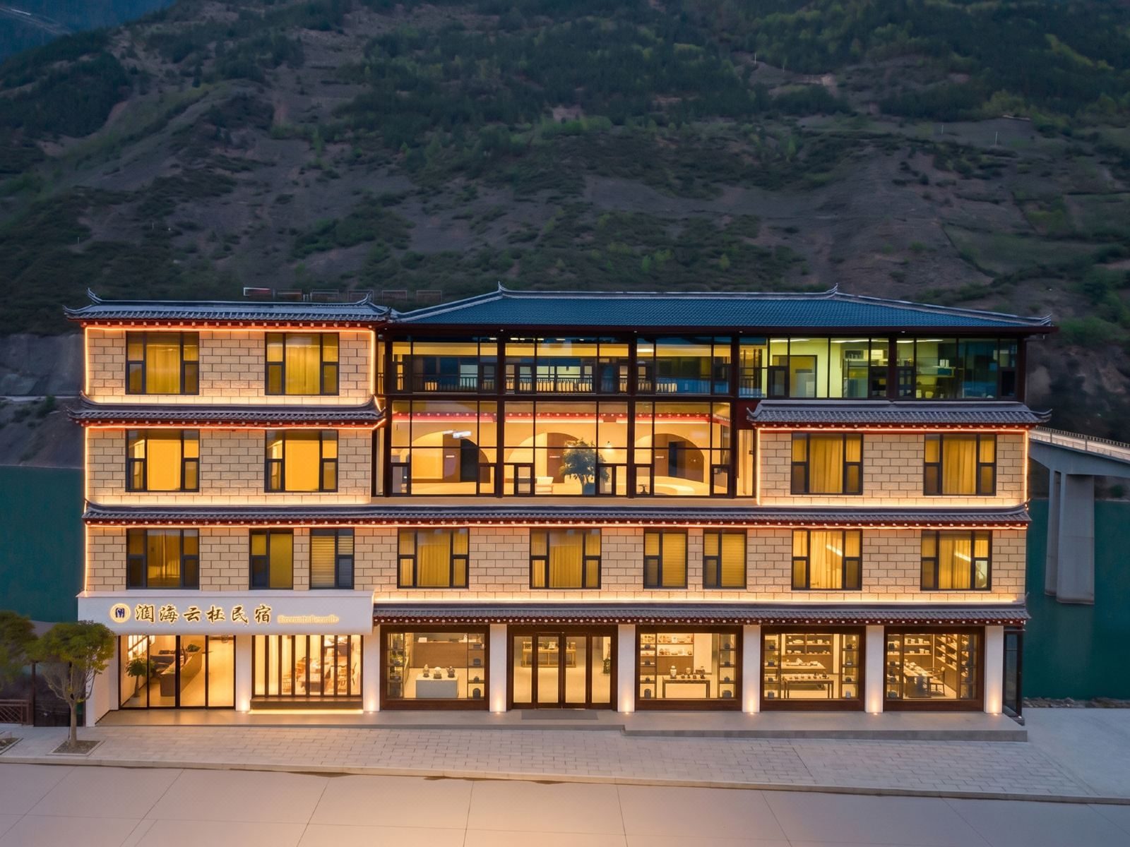 Runhai Yunqi — the painted Tibetan timber facade lit at dusk