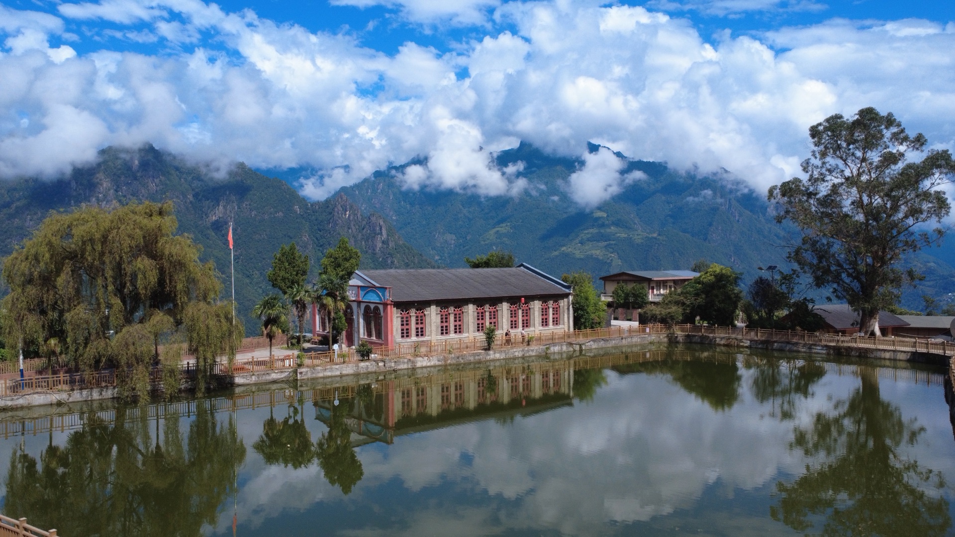 The church on its pond at Laomudeng, Crown Peak behind